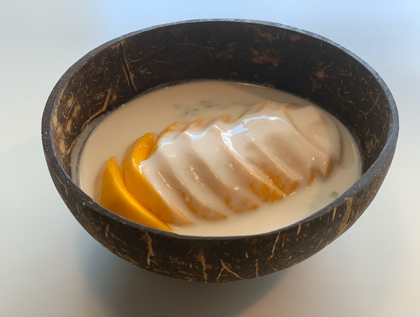 A coconut bowl filled with mango and yogurt