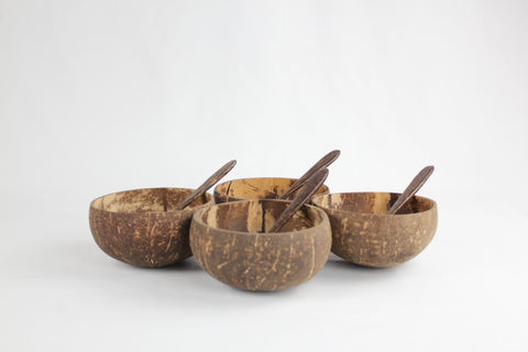 Set of four coconut bowls with wooden spoons