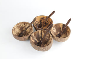Top view of four coconut bowls with spoons